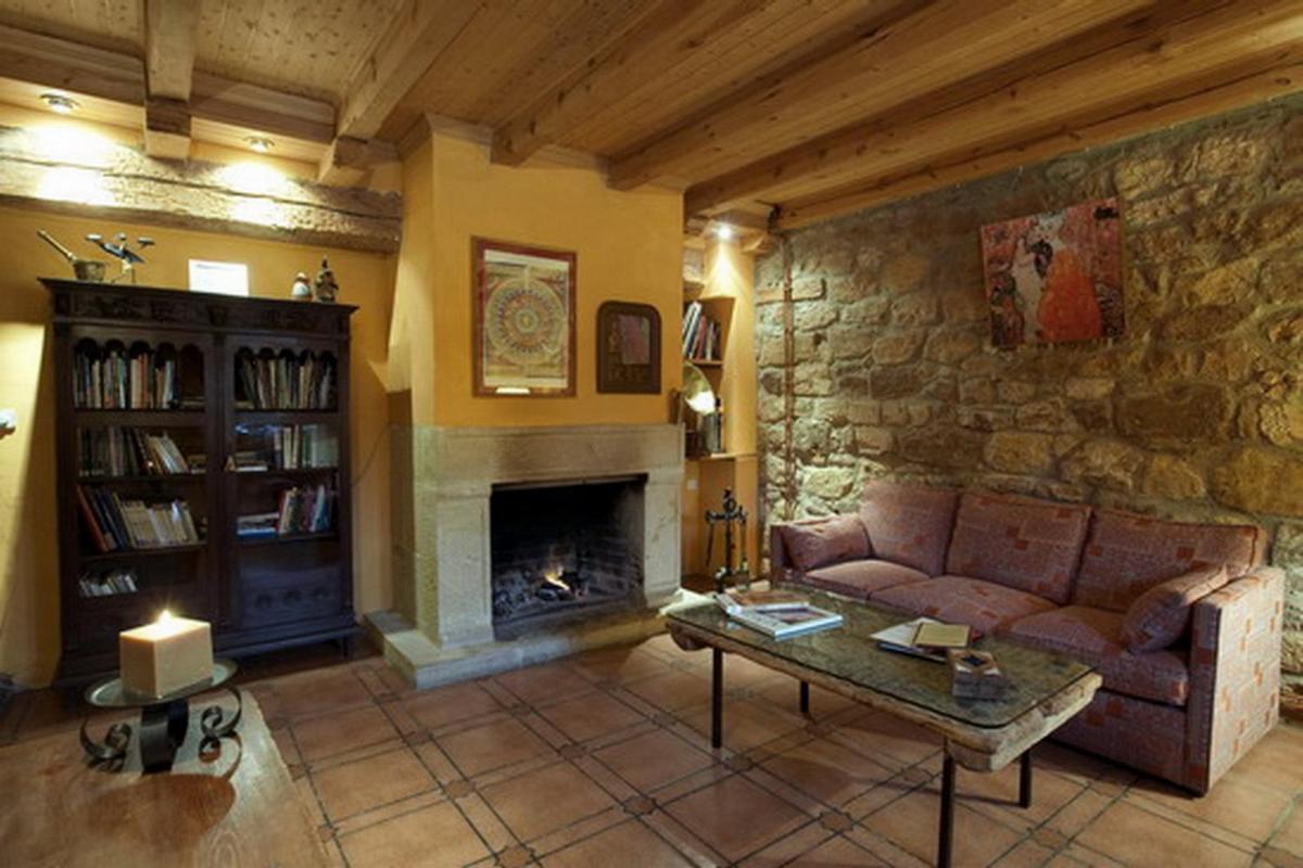 Una sala de estar con un sofá y una chimenea. en Posada Real La Vieja Chimenea-Spa, en Herreros