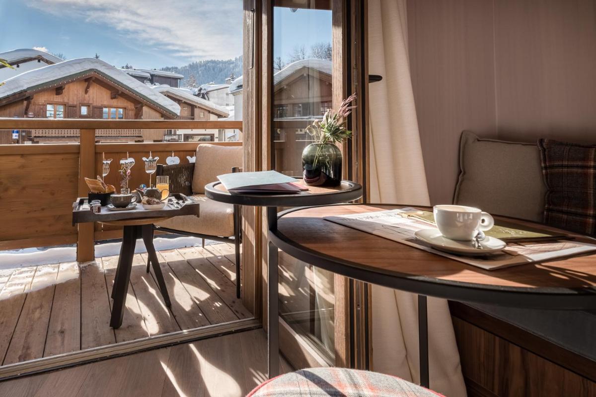 un balcon avec une table et une tasse de café dans l'établissement Coeur de Megève, à Megève