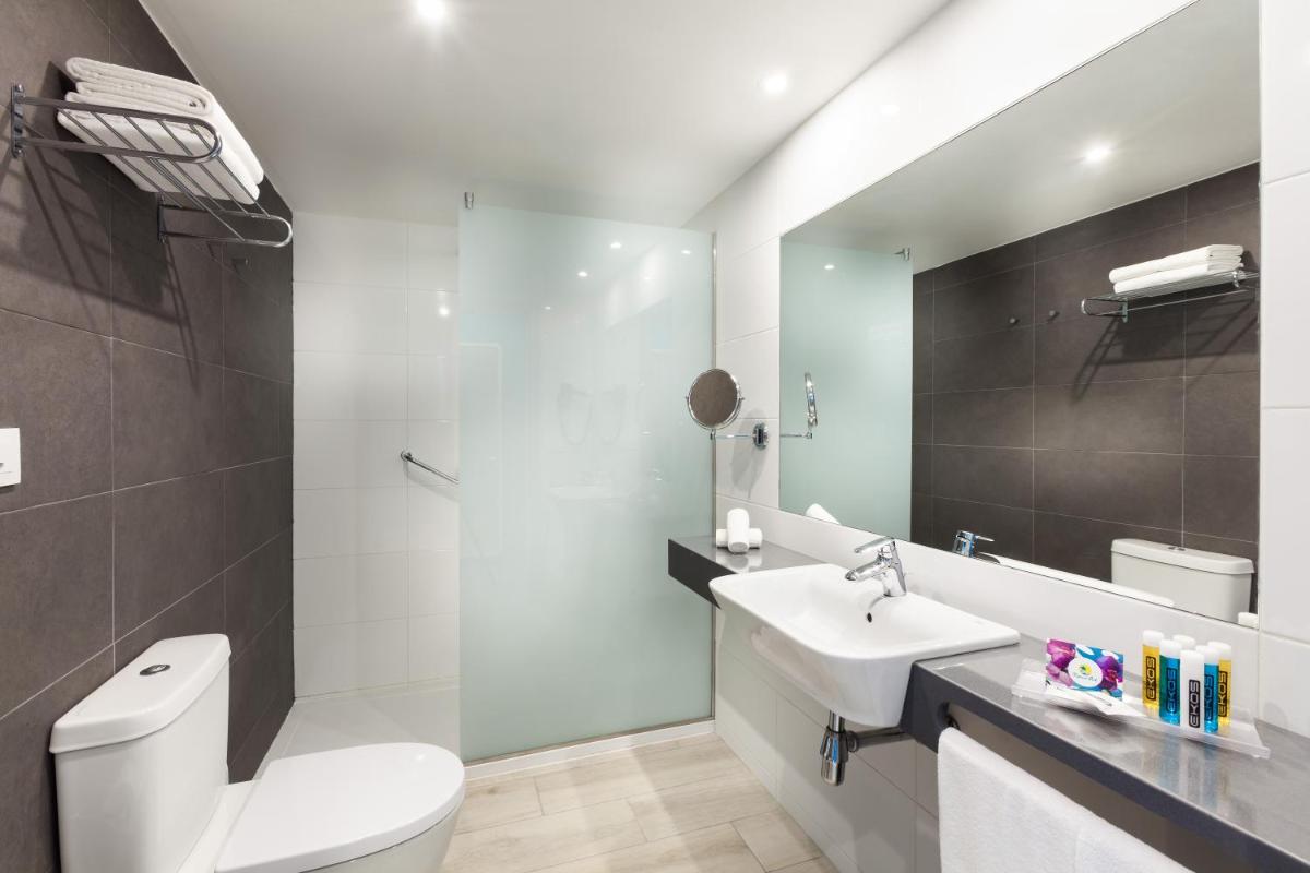 Un baño con un inodoro blanco y un lavabo. en Hotel Tropical Park, en Callao Salvaje