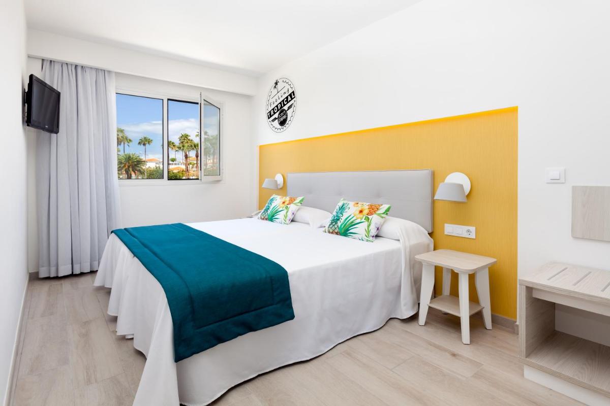 Una habitación de hotel con una cama grande y una ventana. en Hotel Tropical Park, en Callao Salvaje