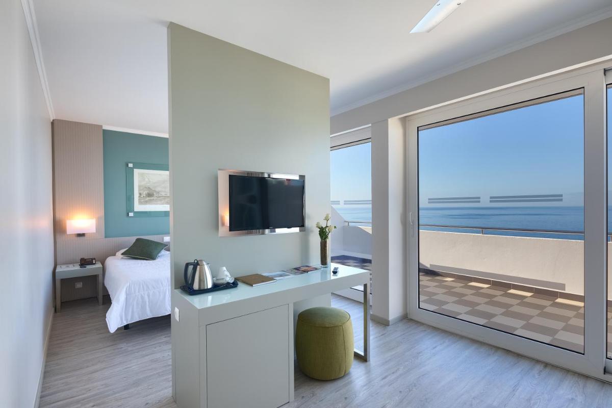 Uma televisão e/ou sistema de entretenimento em Hotel Orca Praia