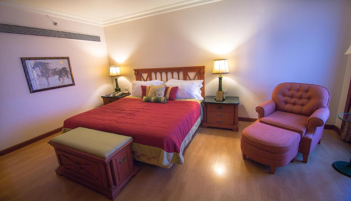 a hotel room with a bed and a chair at The Orchid Hotel Mumbai Vile Parle in Mumbai