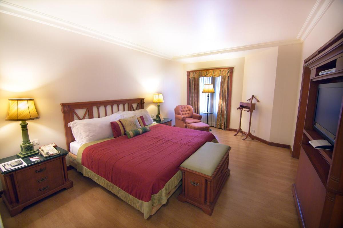 a bedroom with a large bed and a television at The Orchid Hotel Mumbai Vile Parle in Mumbai