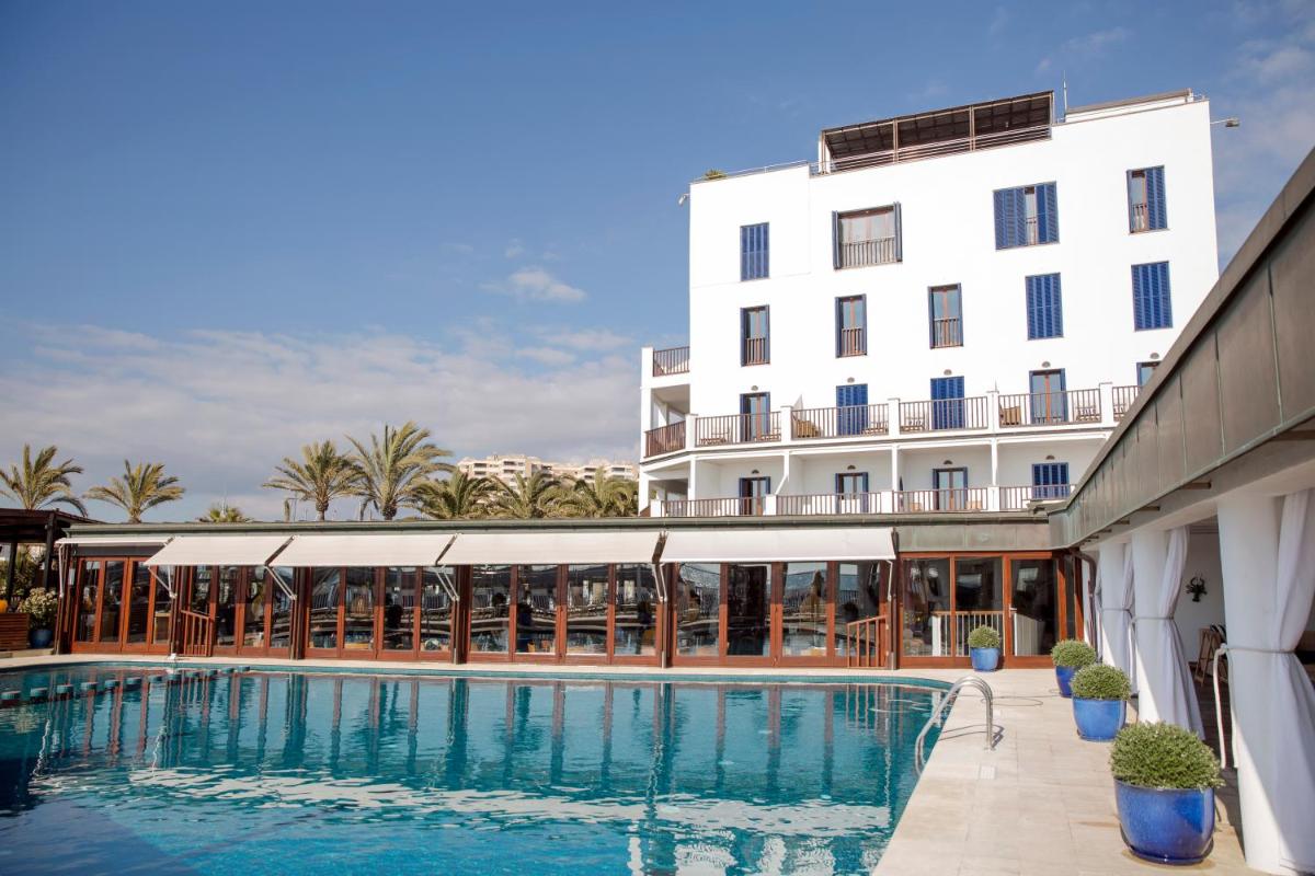 un hotel con piscina frente a un edificio en Portixol Hotel & Restaurant, en Palma de Mallorca