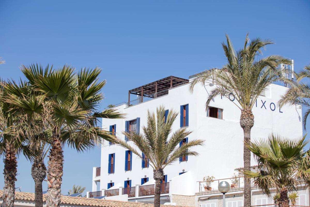 Un edificio blanco con palmeras delante. en Portixol Hotel & Restaurant, en Palma de Mallorca