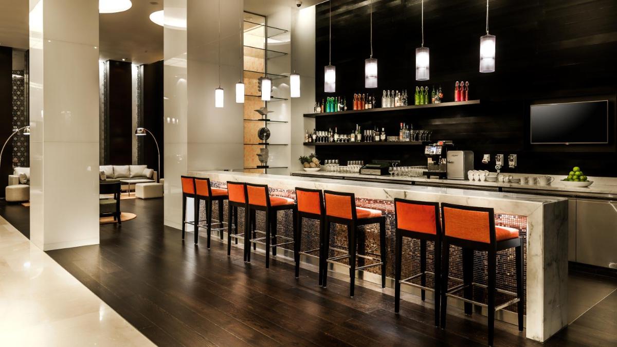 a bar with orange chairs in a room at Hyatt Place Gurgaon Udyog Vihar in Gurgaon