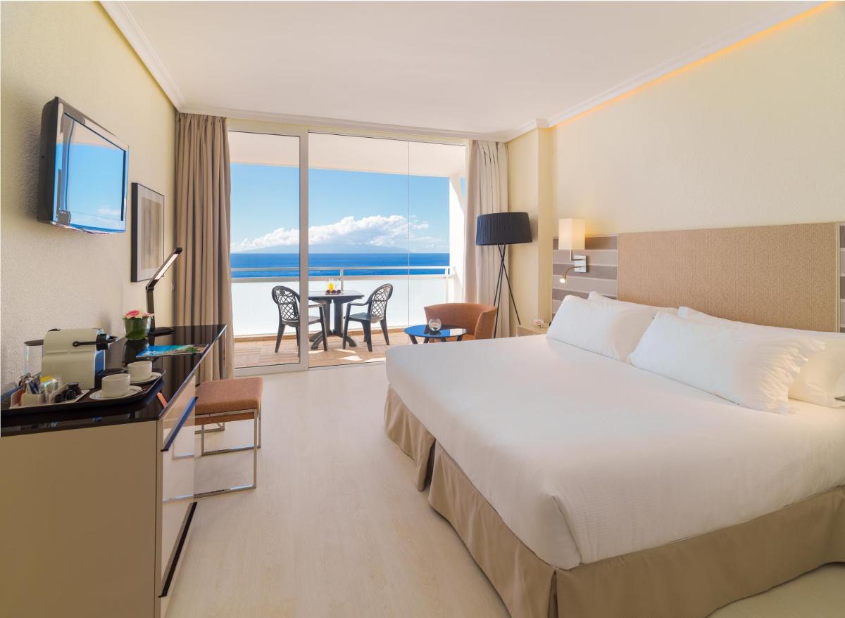 Una habitación de hotel con una cama y vista al océano. en H10 Gran Tinerfe - Adults Only, en Adeje