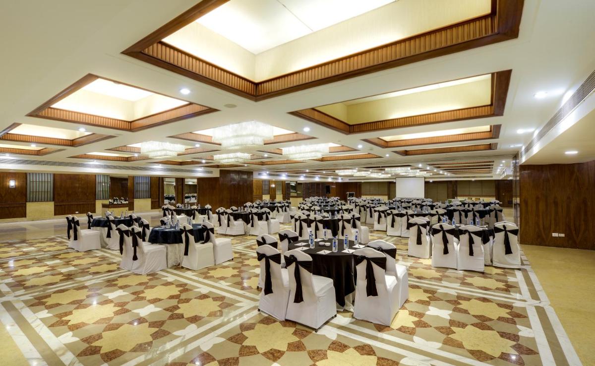 a banquet hall with tables and chairs in a room at Pride Plaza Hotel, Ahmedabad in Ahmedabad