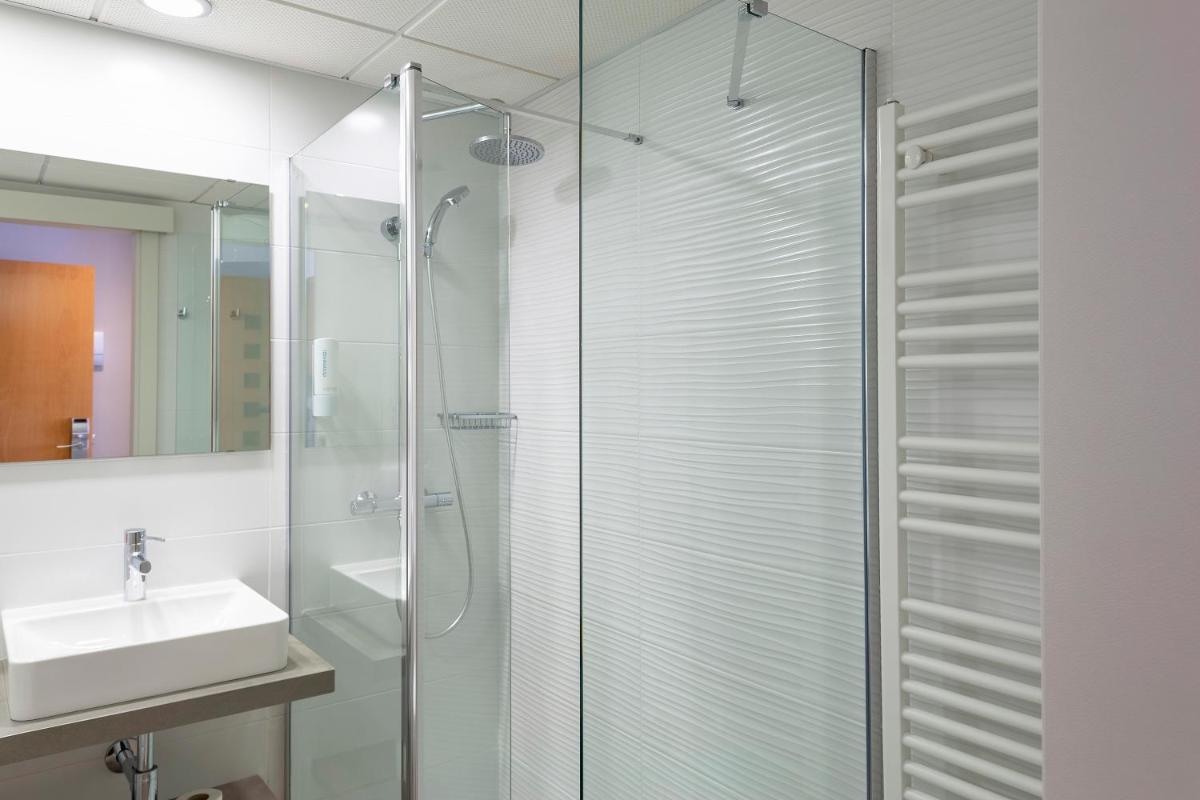 Un baño con ducha de cristal y lavabo. en Hotel & Spa Real Jaca, en Jaca