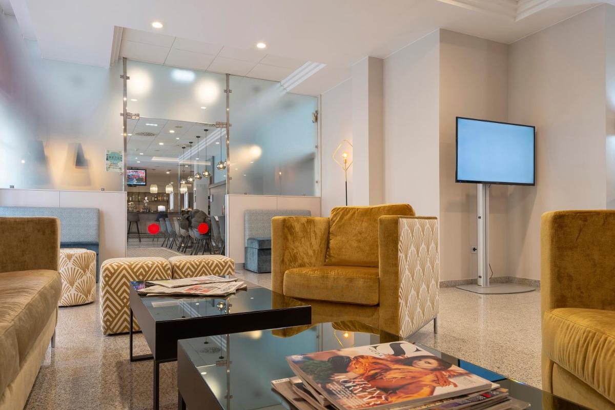 Una sala de estar con un sofá y sillas y un televisor. en Hotel & Spa Real Jaca, en Jaca