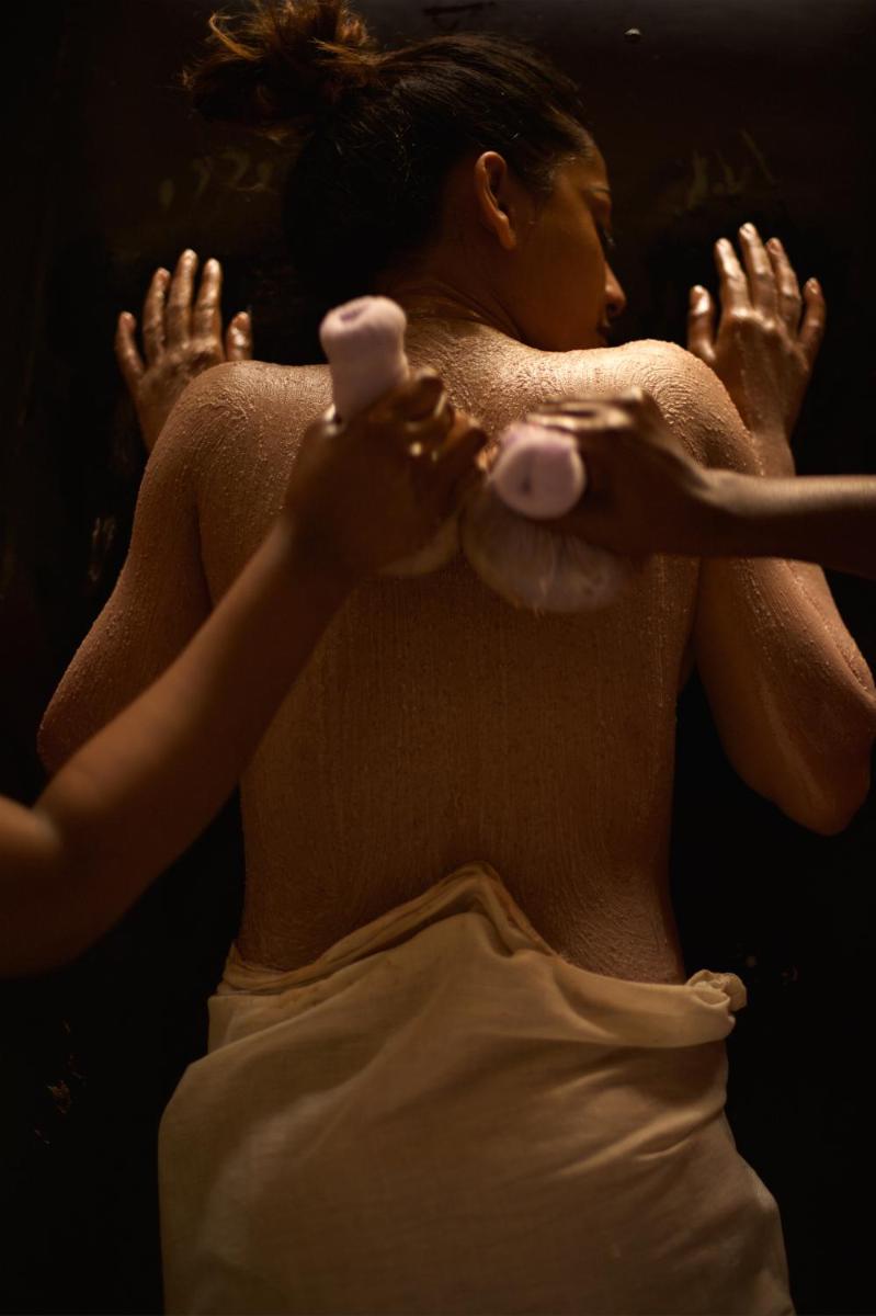 a woman holding a tennis racket with her hands at Palais De Mahe - A CGH Earth Experience in Puducherry