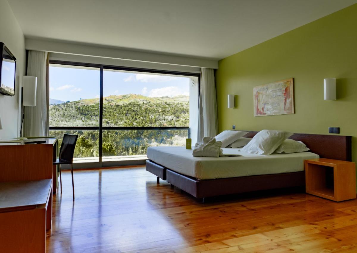 um quarto com uma cama e uma janela grande em Monte Prado Hotel & Spa em Melgaço mais 75 fotografias