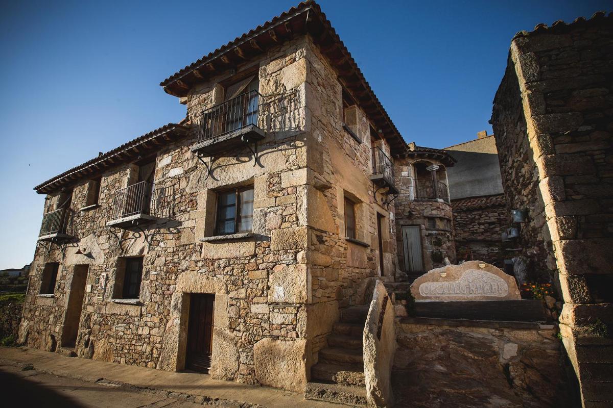 un antiguo edificio de piedra con balcón. en Orgullo Rural, en Bermellar