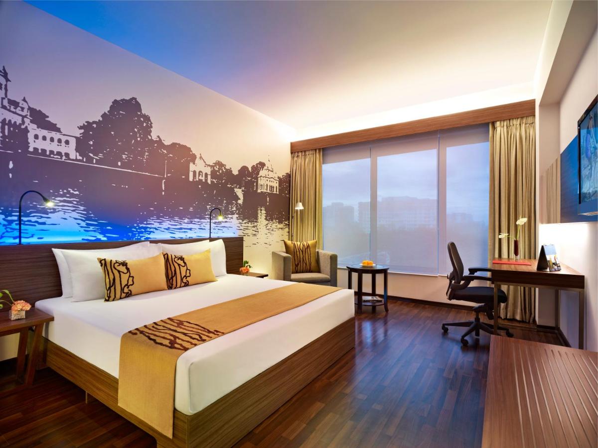 a bedroom with a large bed and a large window at Vivanta Kolkata EM Bypass in Kolkata