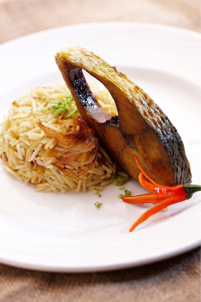 a plate of food with rice and a fish on it at Vivanta Kolkata EM Bypass in Kolkata