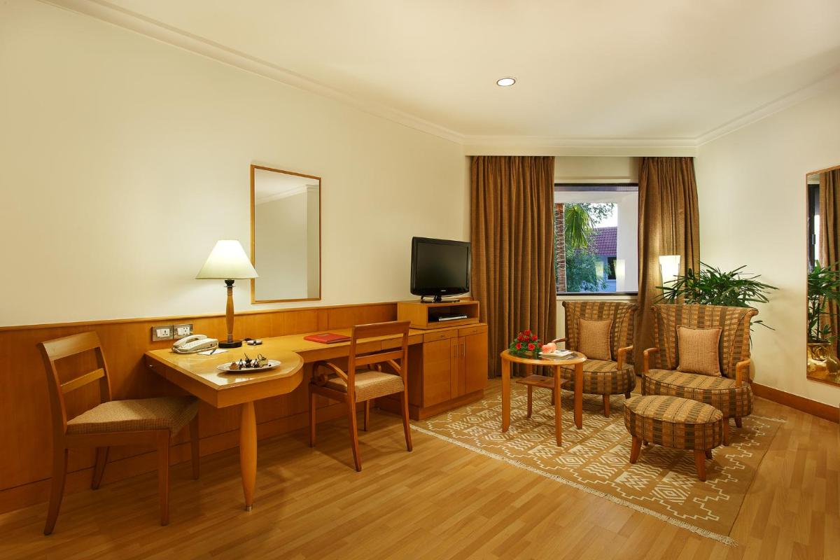 a hotel room with a desk and a television at Trident Chennai in Chennai