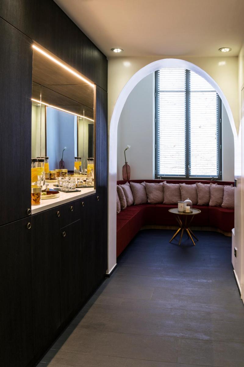 un salon avec un canapé rouge et une table dans l'établissement Carlton Hotel Lyon - MGallery Collection, à Lyon