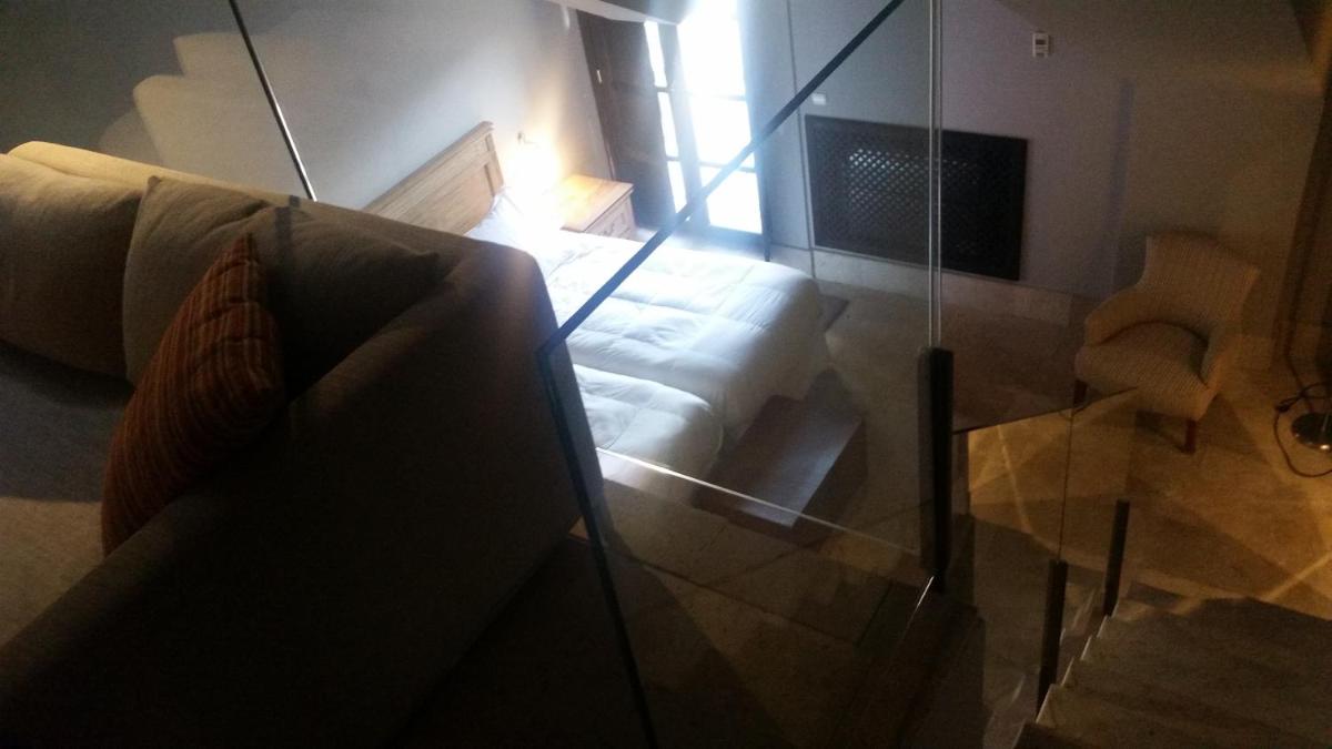 sala de estar con sofá y pared de cristal en Hotel Palacio de Mengibar, en Mengíbar