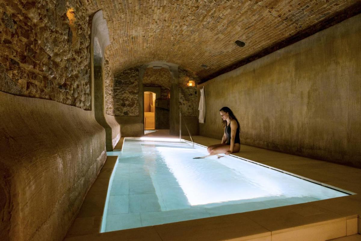 una mujer sentada en una piscina en un edificio en Balneari Termes Victòria, en Caldes de Montbui 48 fotos más