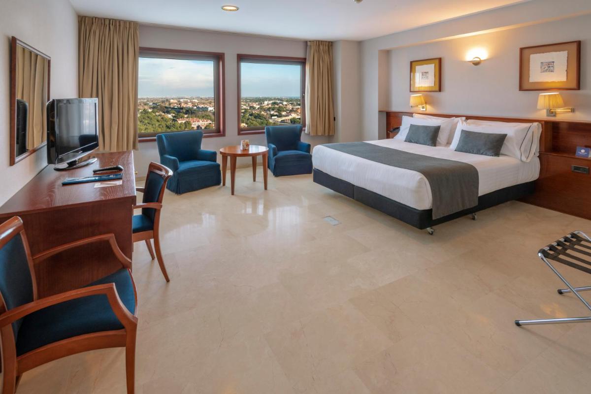 una habitación de hotel con una cama y un televisor en Gran Hotel Rey Don Jaime, en Castelldefels