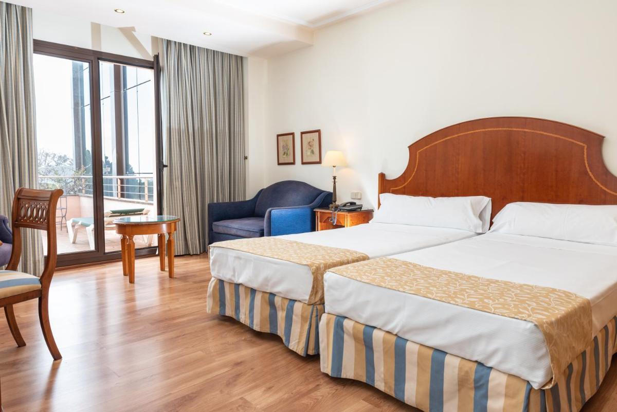 una habitación de hotel con una cama y una silla en Termes Montbrio Hotel & Spa, en Montbrió del Camp