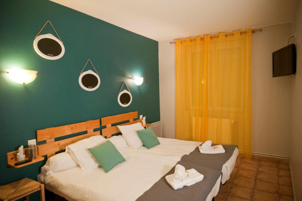 Un ou plusieurs lits dans un hébergement de l'établissement Logis hôtel restaurant Auberge de l'Espinouse