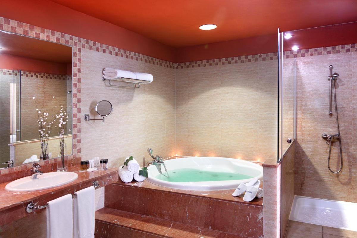 Un baño con bañera, ducha y lavabo. en Occidental Jandía Playa, en Morro del Jable