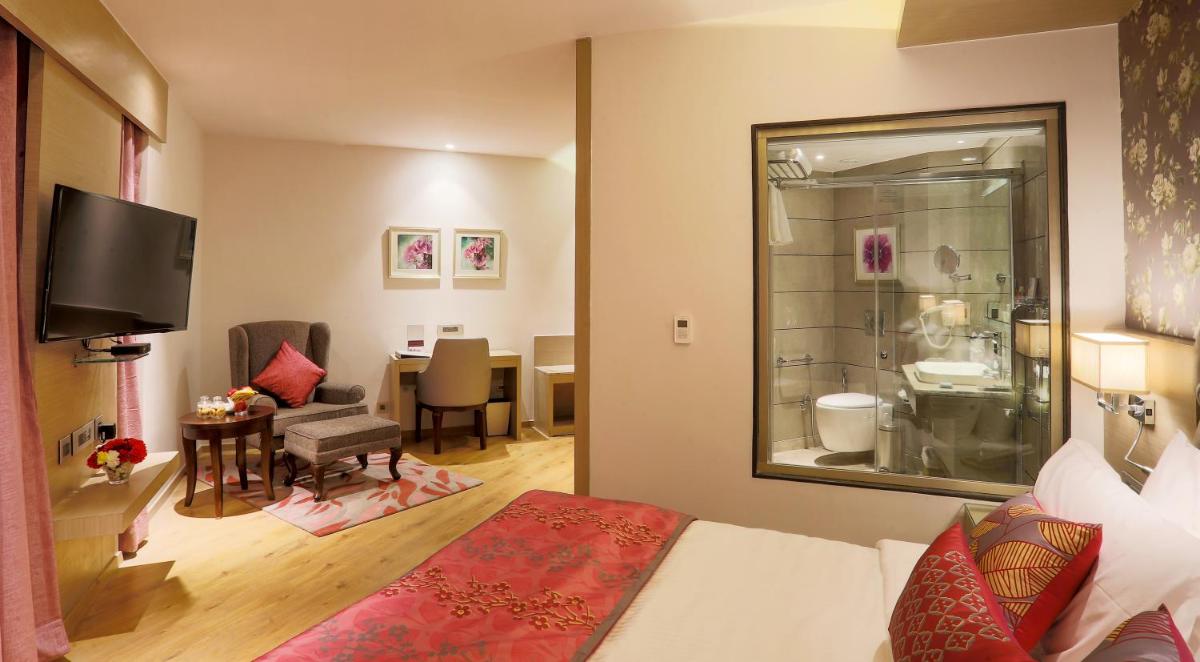 a hotel room with a bed and a living room at Welcomhotel by ITC Hotels, Shimla in Shimla