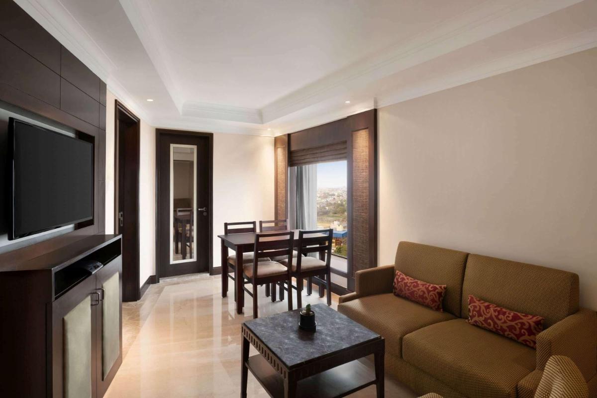 a living room with a couch and a table at Ramada Plaza Chennai in Chennai