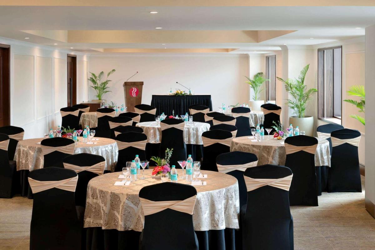 a banquet hall with tables and chairs in a room at Ramada Plaza Chennai in Chennai +127 photos