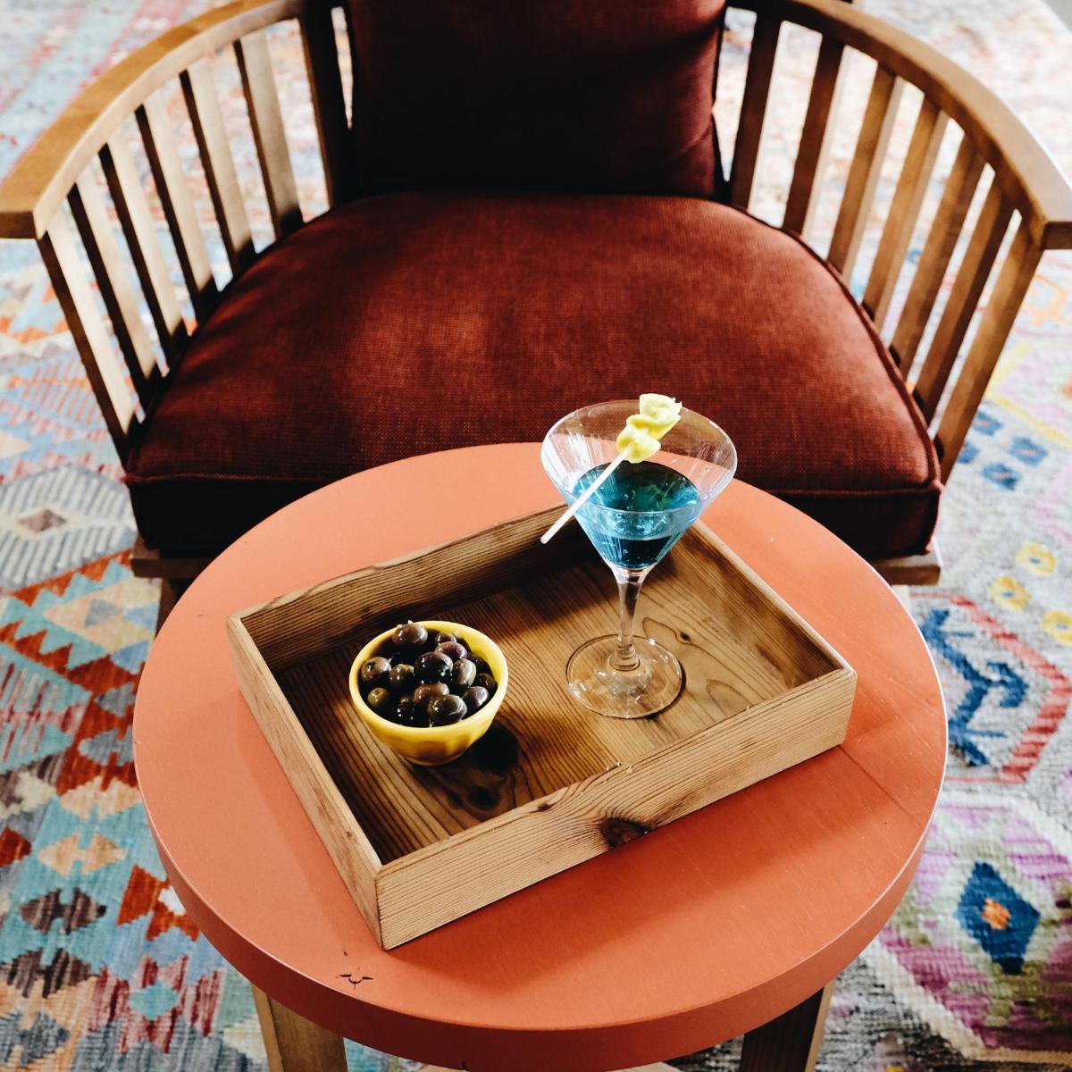 uma mesa com um tabuleiro com um copo e uma taça de azeitonas em FeelViana Sport Hotel em Viana do Castelo mais 89 fotografias