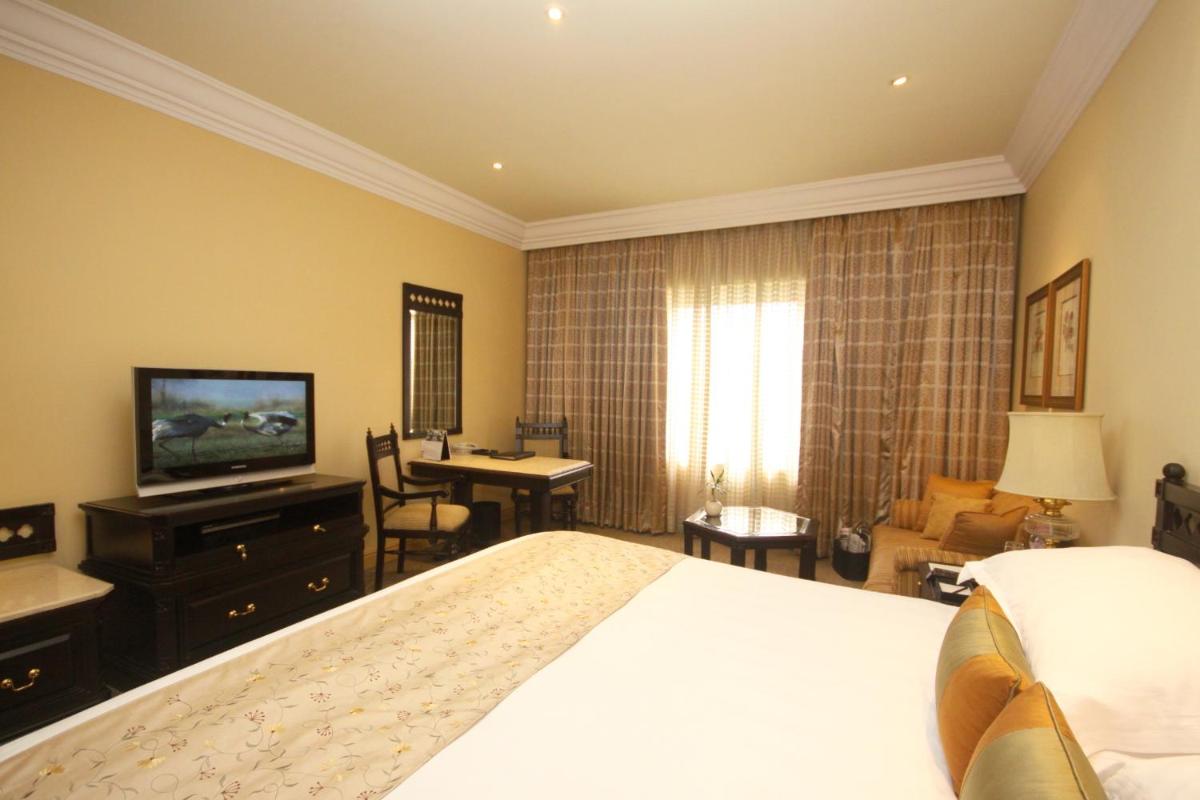 a hotel room with a bed and a television at Taj Bengal in Kolkata