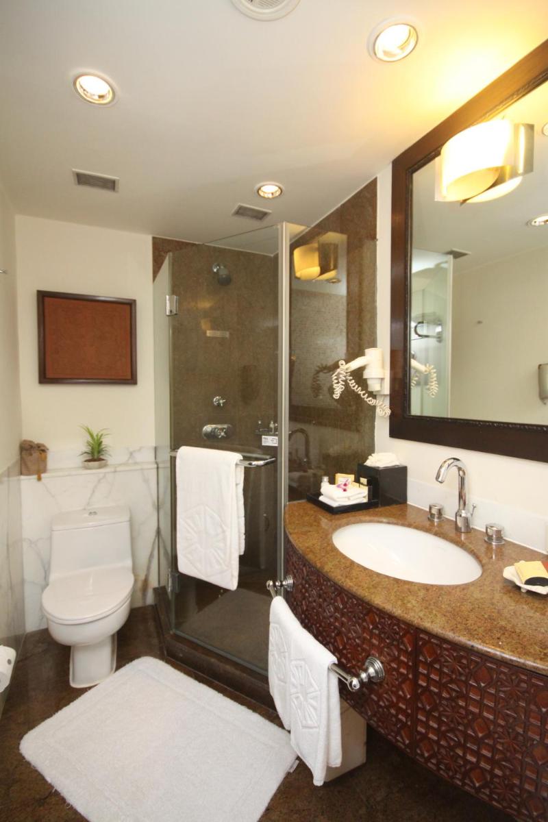 a bathroom with a sink and a shower and a toilet at Taj Bengal in Kolkata