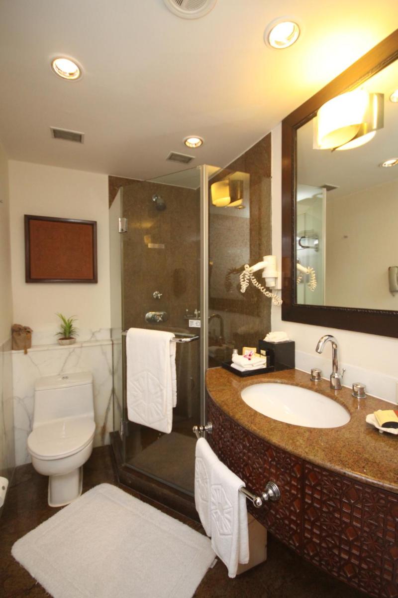 a bathroom with a sink and a shower and a toilet at Taj Bengal in Kolkata