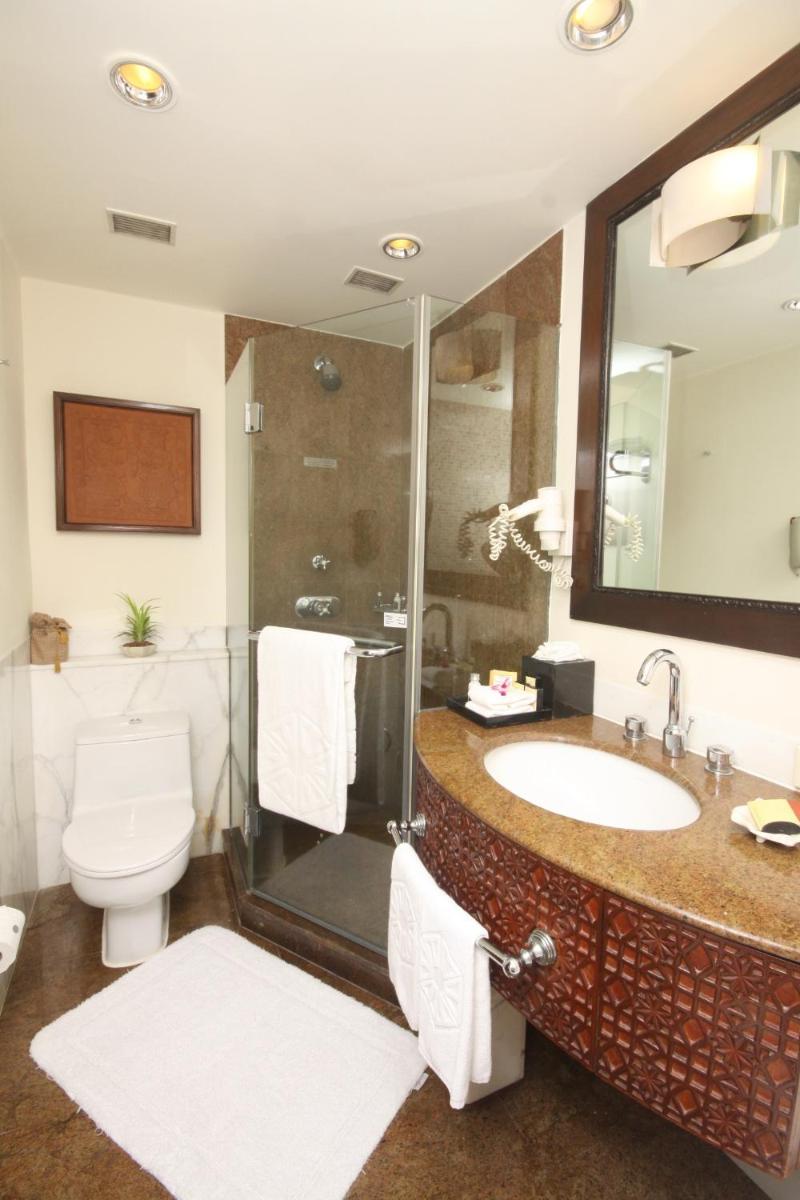a bathroom with a sink and a shower and a toilet at Taj Bengal in Kolkata