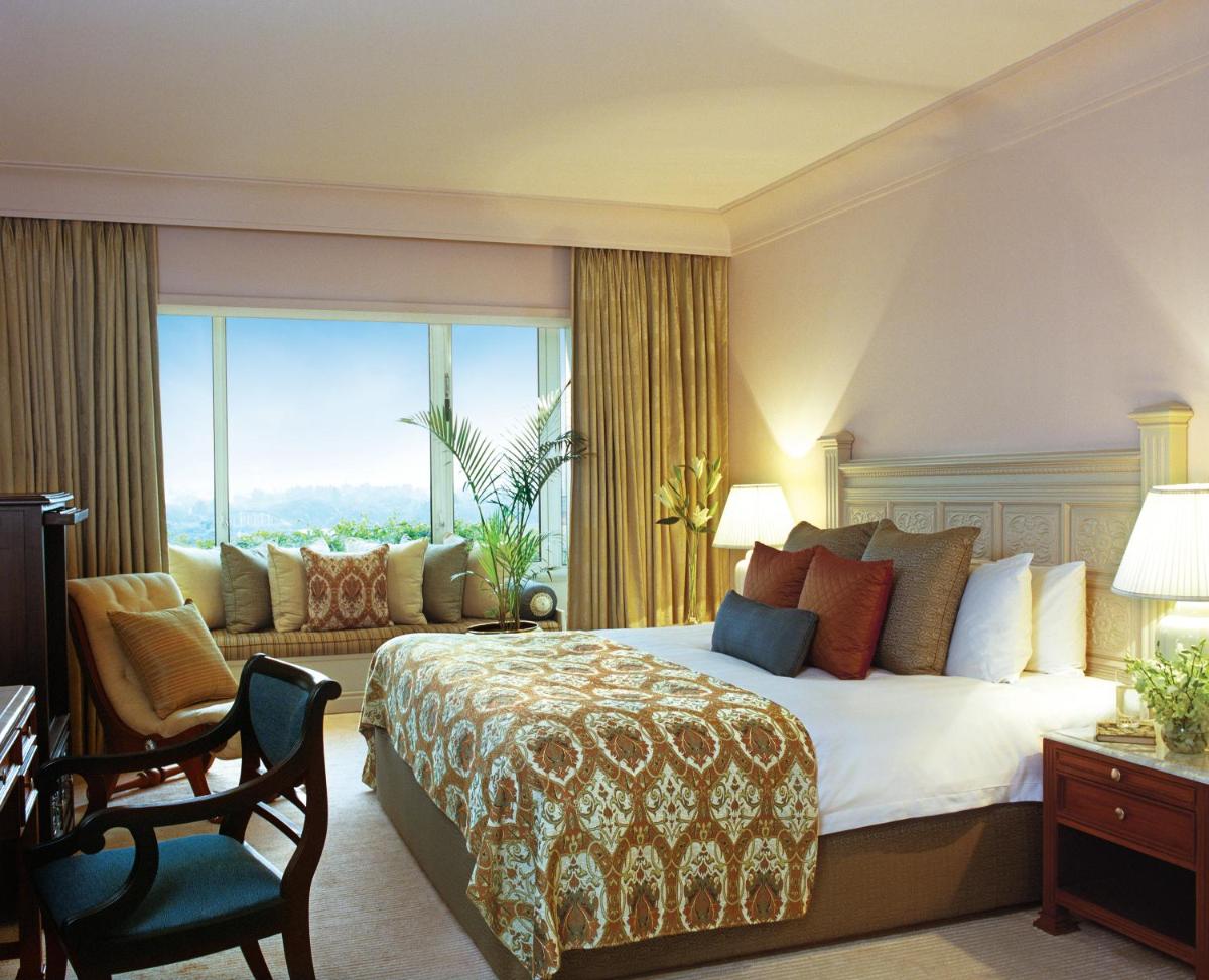a hotel room with a bed and a large window at Taj Bengal in Kolkata