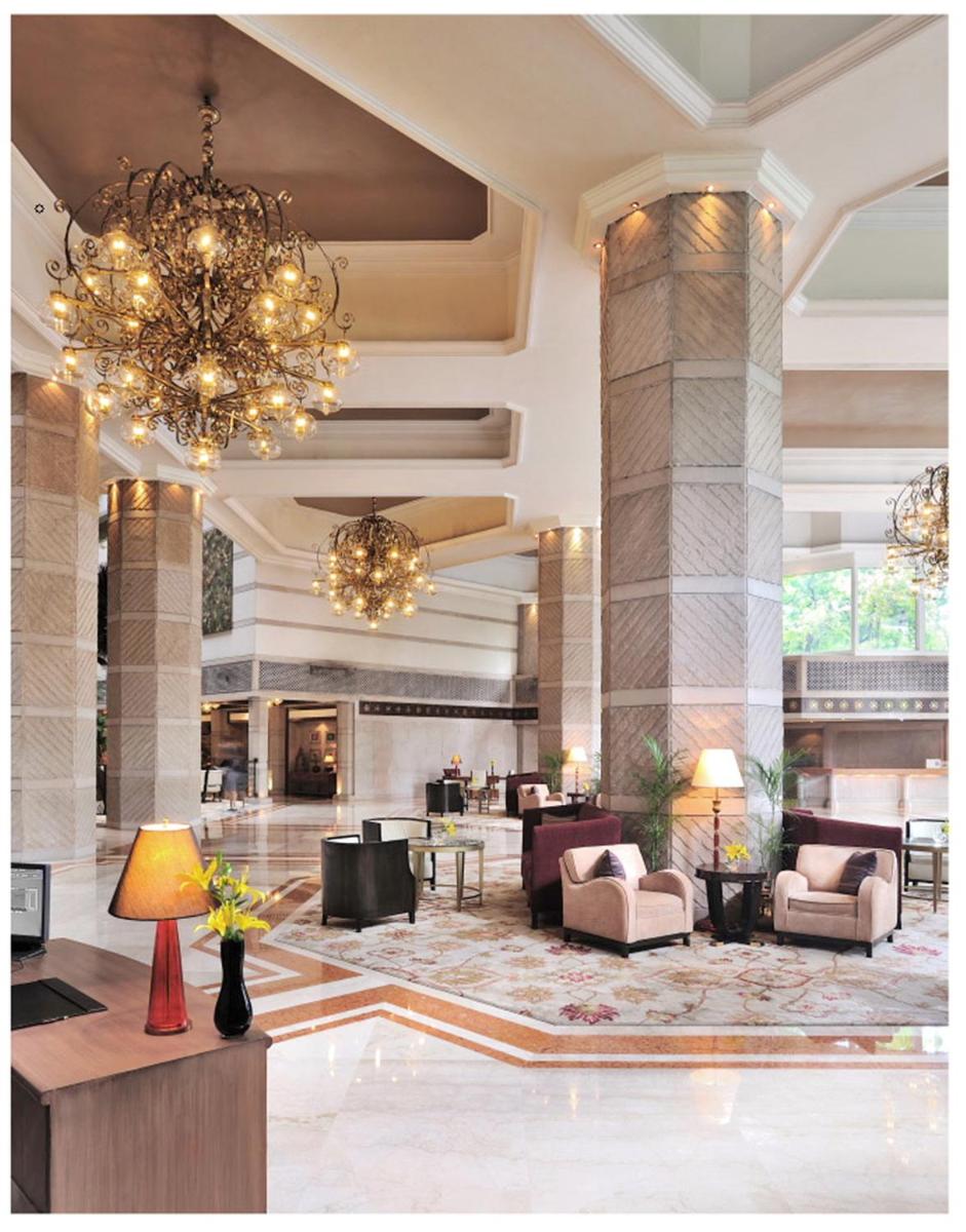 a lobby of a hotel with a chandelier at Taj Bengal in Kolkata