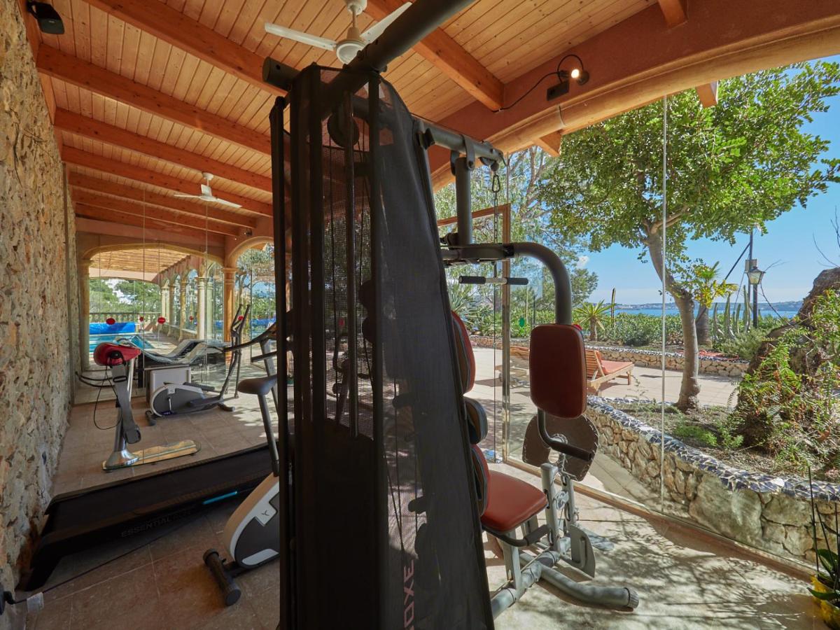 un gimnasio con equipamiento de ejercicio y vistas al océano en Hotel Petit Cala Fornells, en Paguera