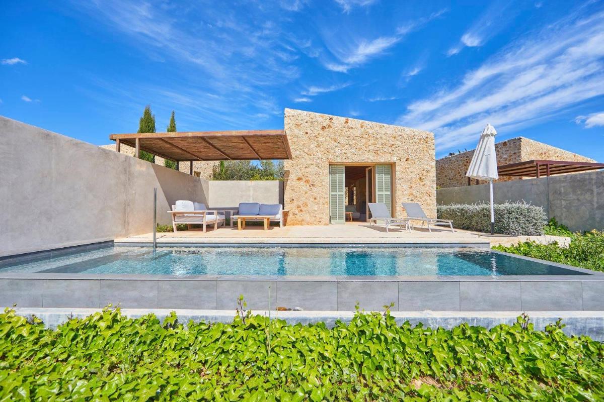 una villa con piscina y sombrilla en Son Penya Adults Only Petit Hotel & Spa, en Sant Llorenç des Cardassar