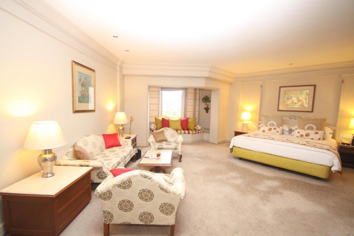 a bedroom with a bed and a living room at Taj Bengal in Kolkata