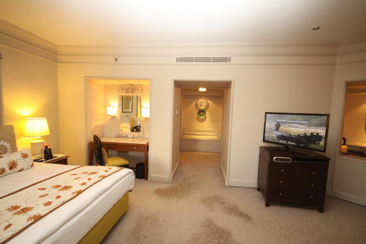 a hotel room with a bed and a television at Taj Bengal in Kolkata