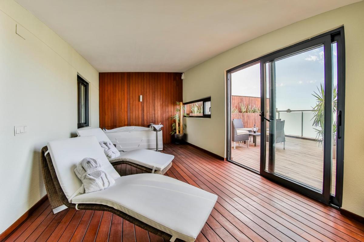 Una sala de estar con un sofá y una cama y un balcón. en Hotel 525, en Los Alcázares