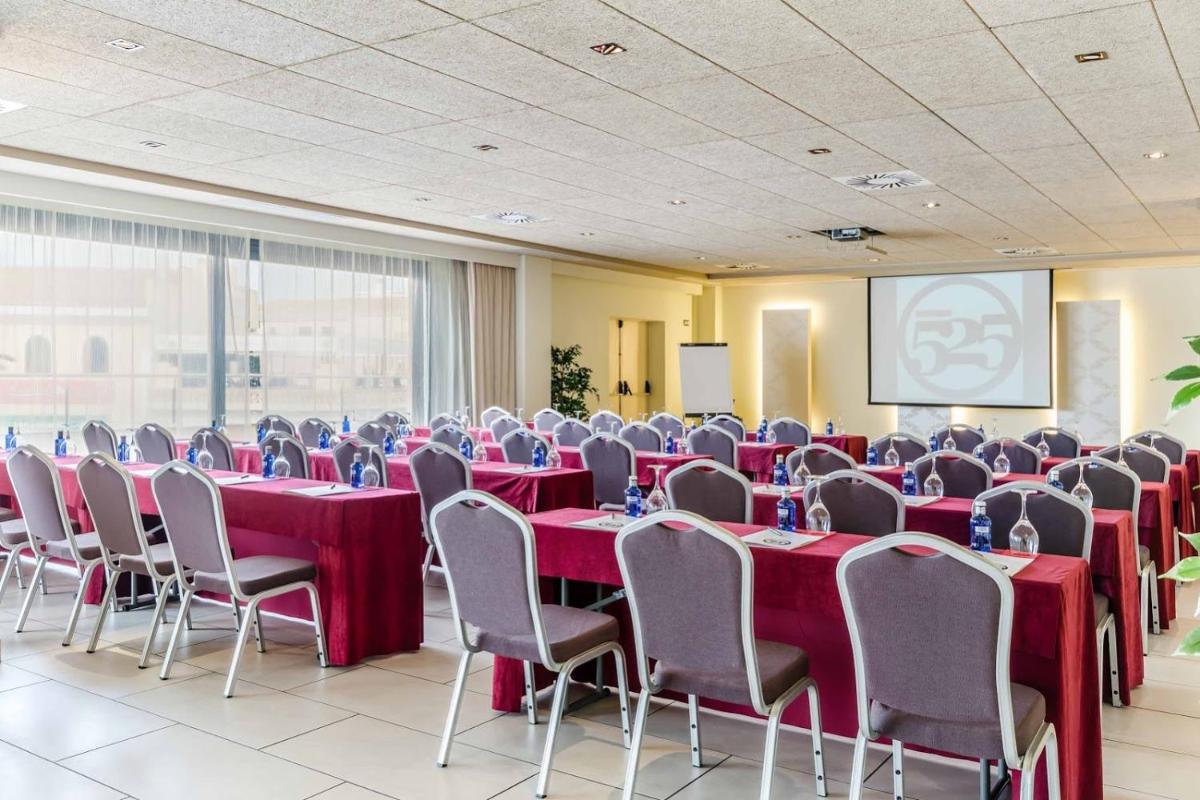 Una sala de conferencias con mesas y sillas rojas y una pantalla. en Hotel 525, en Los Alcázares 123 fotos más