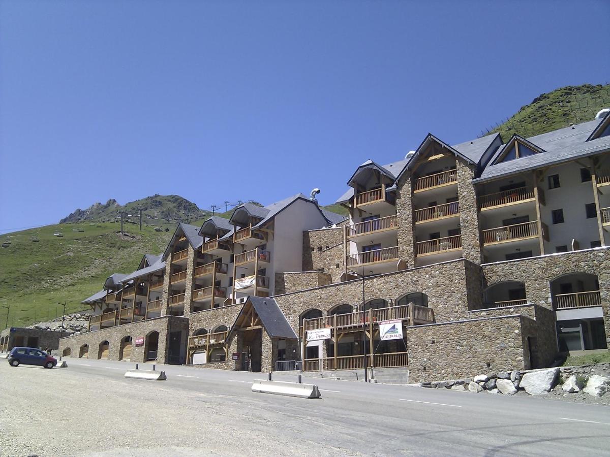 un grand bâtiment sur le côté d'une route dans l'établissement Résidence Mer & Golf Tourmalet, à La Mongie
