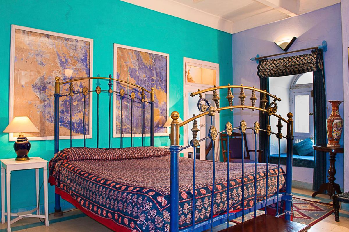 a bedroom with a bed with blue walls at Neemrana Fort-Palace in Neemrana