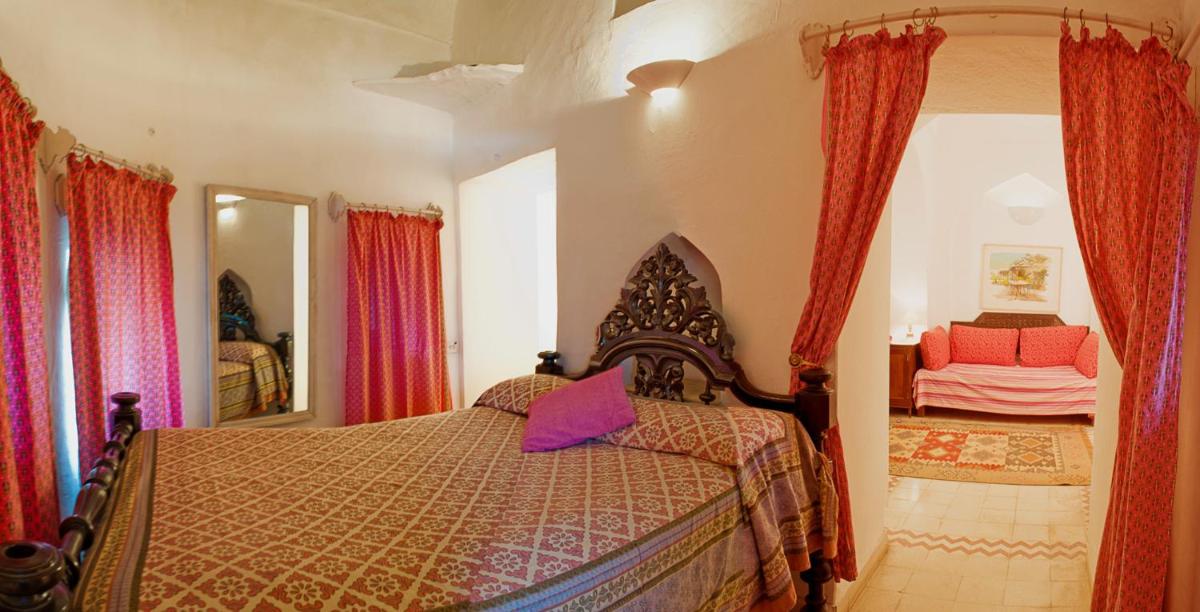 a bedroom with a bed and a mirror at Neemrana Fort-Palace in Neemrana