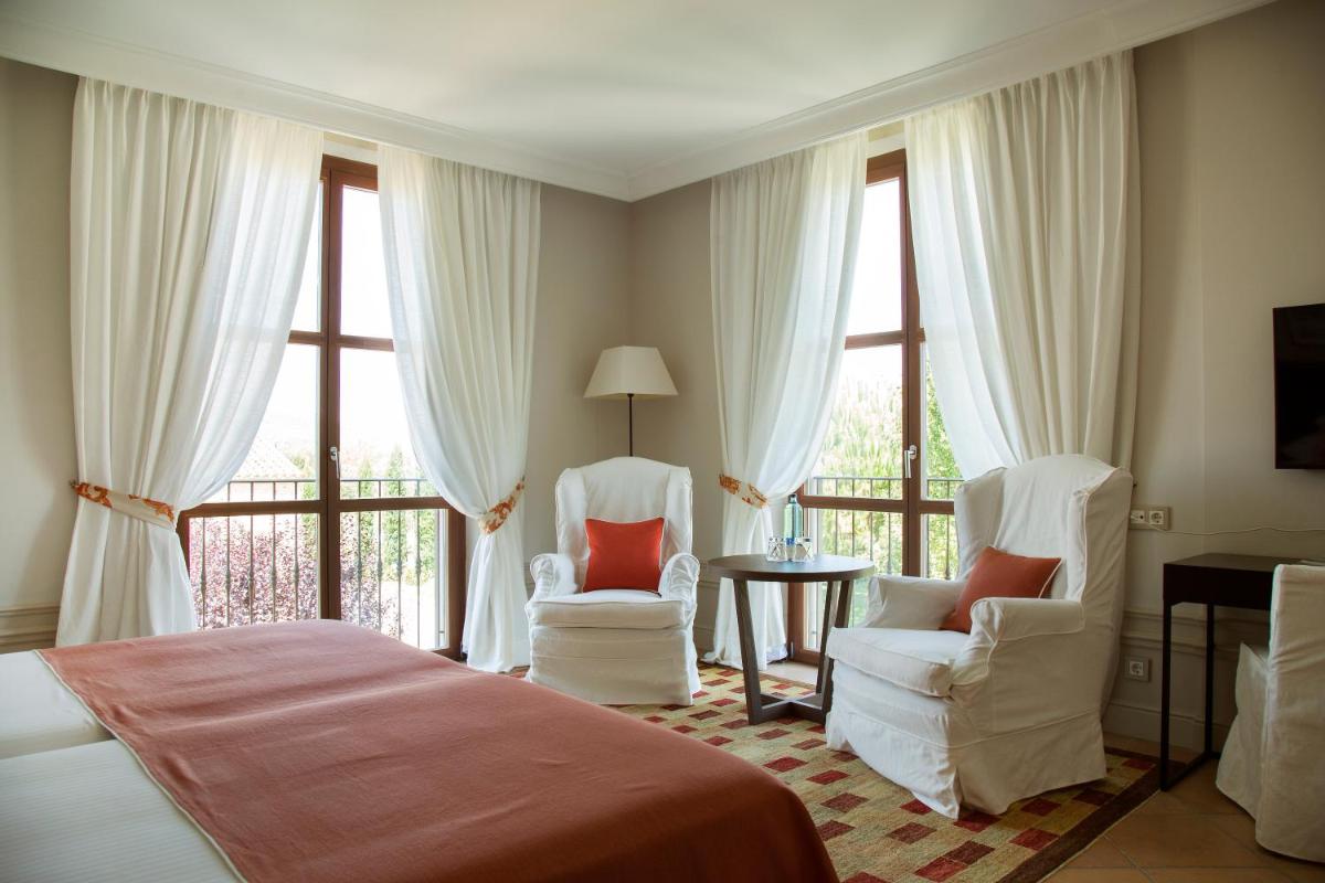 1 dormitorio con 2 sillas, 1 cama y ventanas en Casa Anamaria Hotel, en Ollers