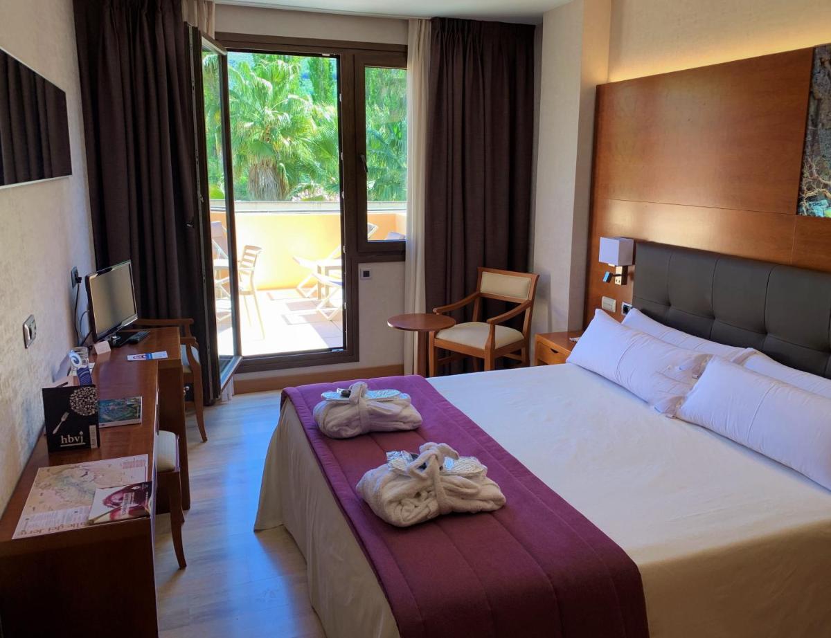 Una habitación de hotel con una cama con toallas. en Hotel Balneario Valle del Jerte, en Valdastillas