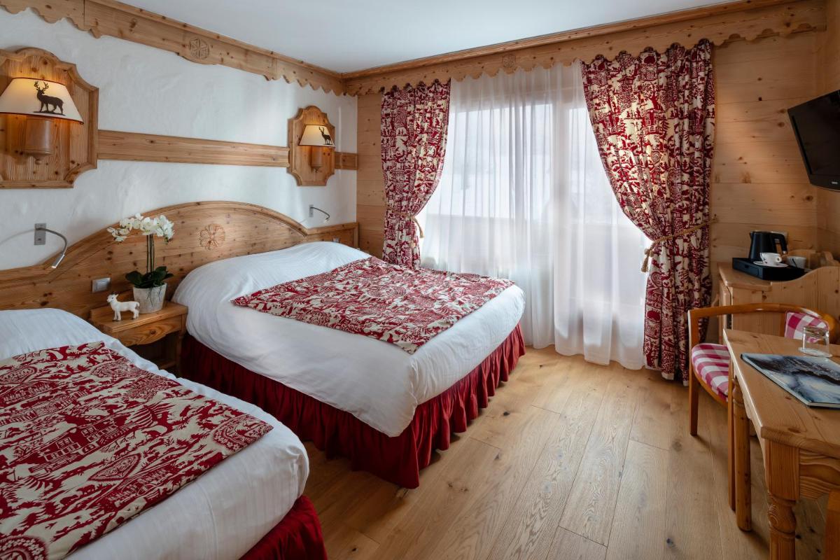 Un ou plusieurs lits dans un hébergement de l'établissement Chalet-Hôtel Neige et Roc, The Originals Relais
