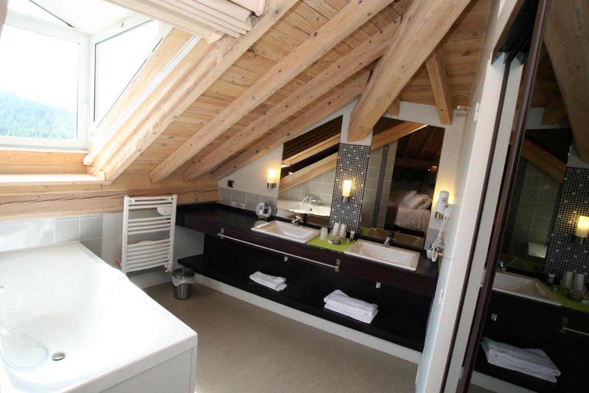 une salle de bain avec deux lavabos et un grand miroir dans l'établissement Hotel Corrieu, à La Llagonne